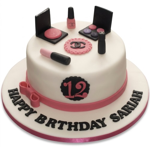 White round birthday cake decorated with edible makeup items, a pink ribbon, bow, and a custom age number.