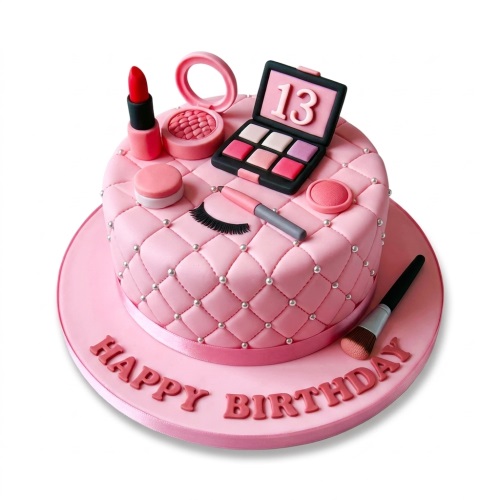 Pink quilted birthday cake with edible makeup decorations, including lipstick, eyeshadow, and brushes.