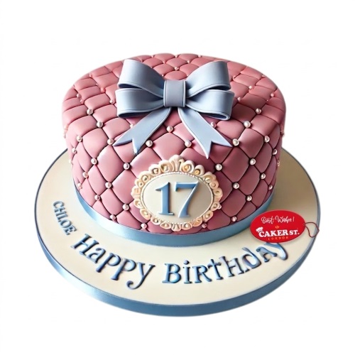 Pink quilted birthday cake with light blue bow, pearl details, and custom age plaque.