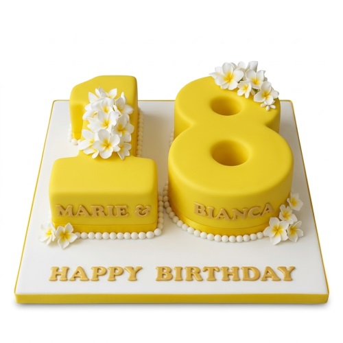 Bright yellow number shaped birthday cake with white sugar flowers and pearl details on a white board with a 'Happy Birthday' message.