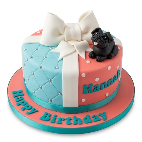 Round single-tier pug dog birthday cake with a white bow, blue quilted side, and coral polka dot side, with 'Happy Birthday' text.