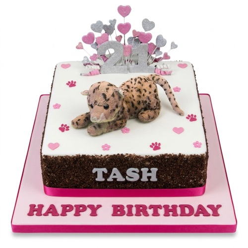 Square white cake with leopard toy, pink and silver glitter hearts, custom age topper, and personalised name.