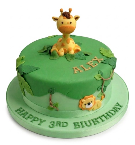 Round jungle safari themed birthday cake with a giraffe, lion, green leaves, and vines.