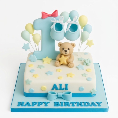 White and blue 1st birthday cake with a number one, teddy bear, baby booties, balloons, and stars.