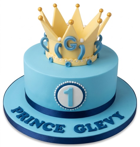 Light blue prince crown cake with number one topper and custom name for a baby boy's first birthday.