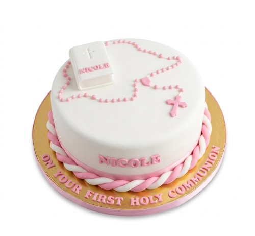 White round First Holy Communion cake with pink rosary, cross, and edible Bible.