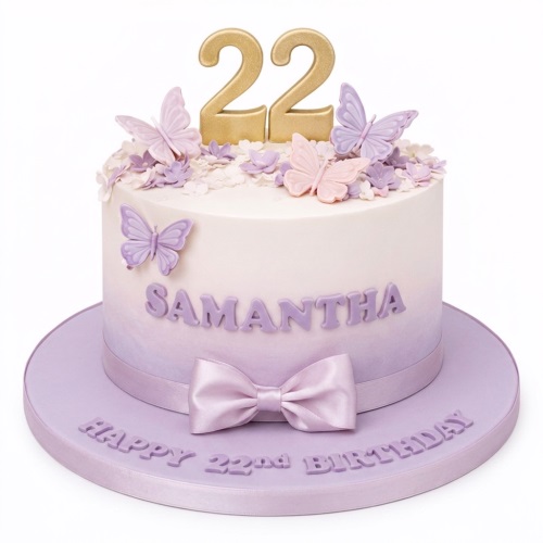 Round single-tier white and lavender ombre cake with gold custom age topper, pink and purple butterflies, small flowers, and a purple satin bow.