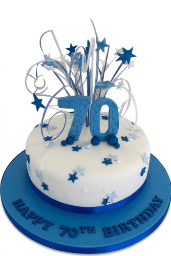 White and blue 70th birthday cake with star burst topper and '70' numbers.