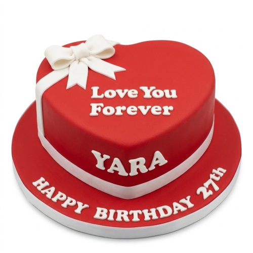 Red heart-shaped birthday cake with white ribbon bow and custom message.
