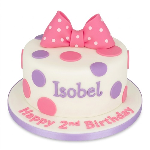 White birthday cake with pink and purple polka dots and a large pink bow.