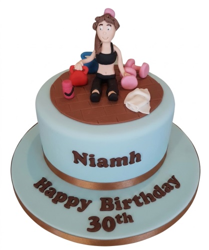 Round light blue gym theme birthday cake with female figure, dumbbells, and custom age.