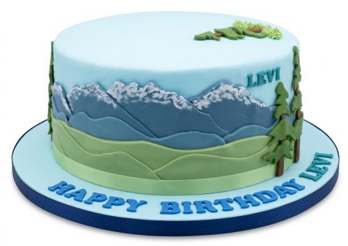 Round light blue cake with edible blue and green layered mountains, white snow caps, and green pine trees.