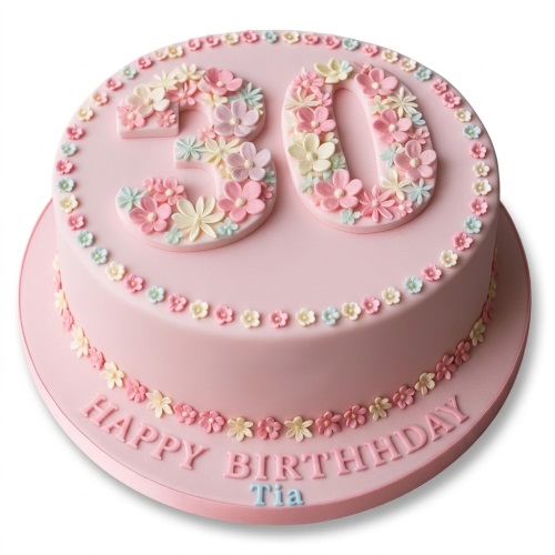 Round pink birthday cake with pastel sugar flowers forming a custom age and border.