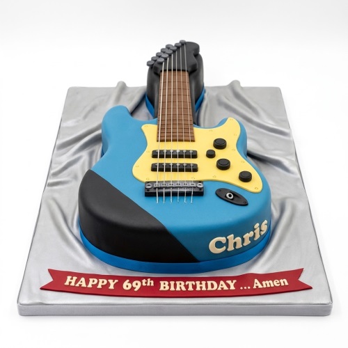 3D sculpted electric guitar birthday cake in blue and yellow with black details, on a silver cake board.