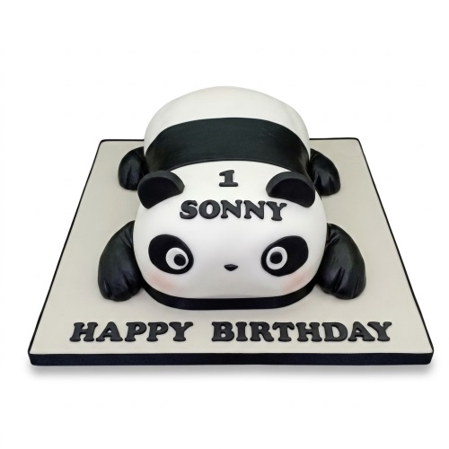 3D sculpted panda birthday cake with black and white icing, lying down on a light-coloured cake board, with space for a custom age and personalised name.