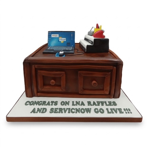 Edible office desk cake with laptop, mouse, and desk organiser for a celebration.