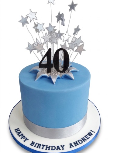 Round blue birthday cake with silver starburst topper and custom age number.