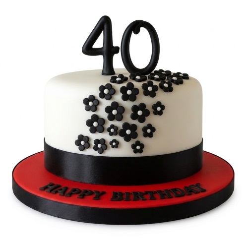 Round white cake with black and white sugar flowers, black ribbon, and a black custom age topper on a red board.