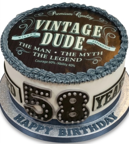 Round white birthday cake with 'Vintage Dude' edible print and custom age on side.