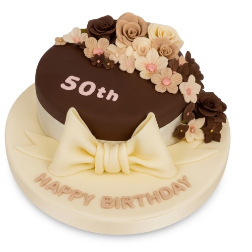 Round chocolate birthday cake with cream and brown sugar flowers, a large bow, and custom age.