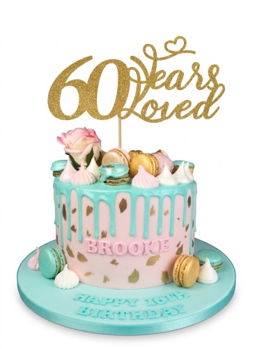Pink and teal drip birthday cake with gold flecks, macarons, meringues, rose, and custom age topper.