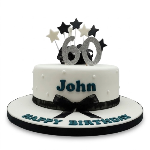 White single-tier birthday cake with black ribbon, black and white star toppers, and silver glitter custom age topper.