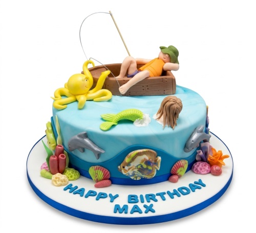 Round blue under the sea birthday cake with a fisherman in a boat, octopus, mermaid tail, dolphins, and coral decorations. Custom message on board.