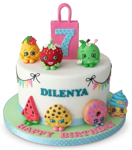 White single-tier cake with Shopkins characters, colourful bunting, and a pink custom age topper.