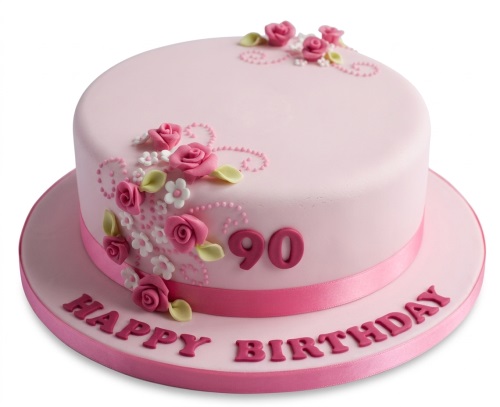 Round pink birthday cake with fondant roses, white flowers, green leaves, and a custom age topper.