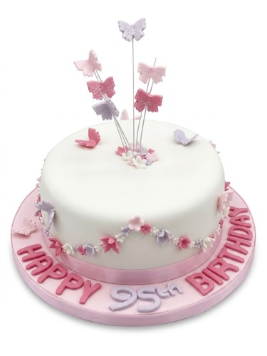 Round white fondant cake with pink and lilac butterflies, floral accents, and a custom age message.