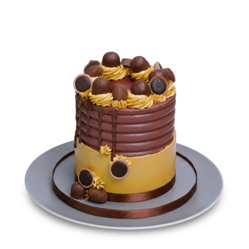 Tall round chocolate drip cake with gold base, topped with chocolate truffles and a brown ribbon.
