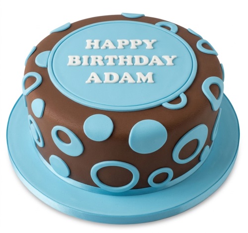 Round brown birthday cake with light blue polka dots and a light blue plaque on top.