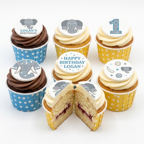 Six cupcakes with elephant toppers, blue and yellow polka dot cases, some chocolate, some vanilla with jam.