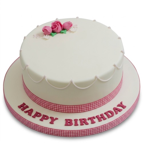 Round white birthday cake with pink roses, green leaves, and a pink gingham ribbon.