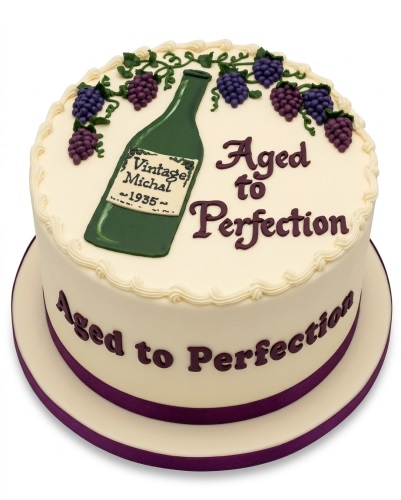 Round cream cake with a green wine bottle, purple grapes, and 'Aged to Perfection' text.