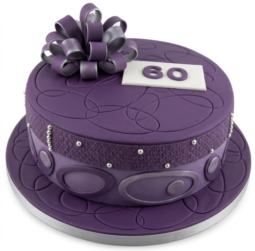 Elegant purple two-tier birthday cake with a large silver and purple bow and abstract swirl patterns.
