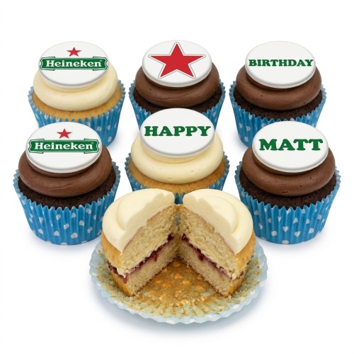 Six cupcakes with Heineken logo, red star, and 'Happy Birthday' toppers, one cut open to show filling.