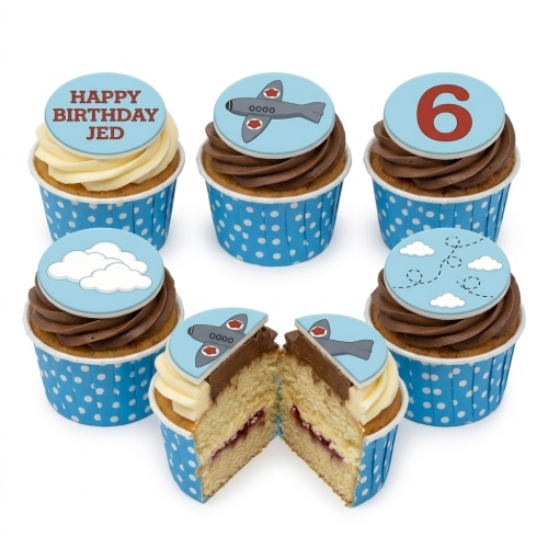 Cupcakes with light blue toppers featuring grey aeroplanes, white clouds, and flight paths. Some toppers have example messages and a custom age number.
