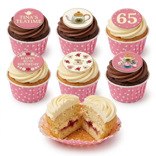Selection of elegant tea party themed birthday cupcakes with pink polka dot wrappers, white and chocolate frosting, and various tea and floral toppers.