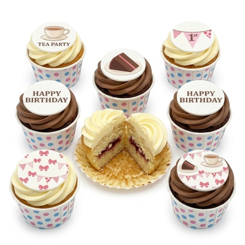 Selection of birthday cupcakes with tea party theme, including teacup, cake slice, bunting, and 'Happy Birthday' toppers, one cupcake cut to show jam filling.