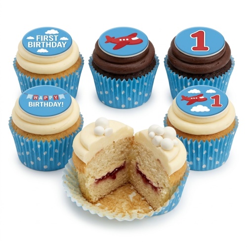 Six cupcakes with blue polka dot wrappers, some with vanilla icing and jam filling, others with chocolate icing. Toppers feature red aeroplanes, the number 1, and "First Birthday" messages.