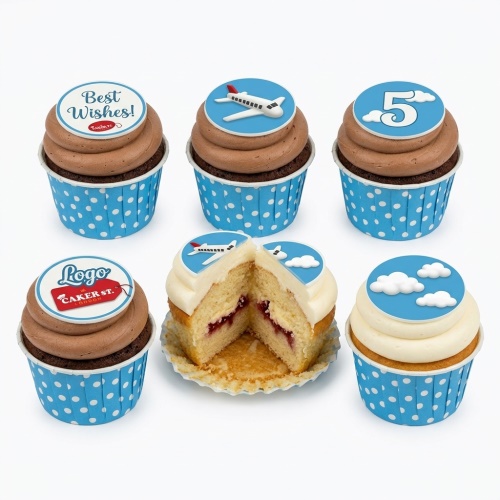Six cupcakes with aeroplane and cloud toppers, one with a number, in blue polka dot wrappers.