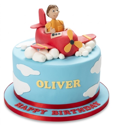 Blue round birthday cake with red airplane and pilot, white clouds, and custom message.