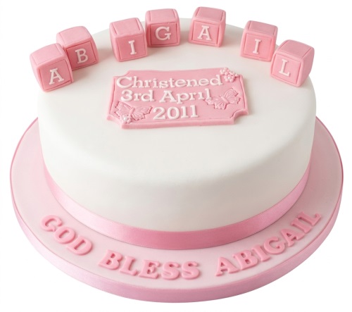 White christening cake with pink personalised alphabet blocks and a custom message plaque for a baby girl.