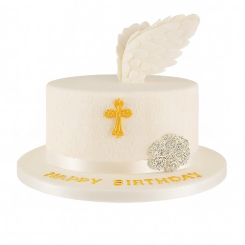 Elegant white birthday cake with white angel wing topper, gold cross, and sparkly decoration.