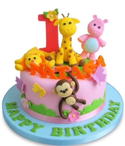 Pink 1st birthday cake with jungle animals, giraffe, hippo, lion, monkey, and butterflies.