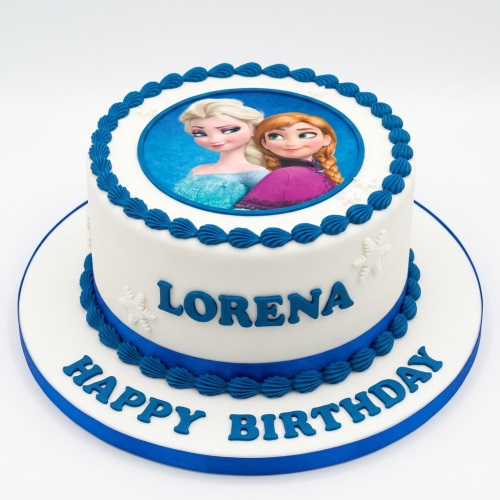 Round white fondant cake with edible Frozen Elsa and Anna image, blue piping, and white snowflakes.