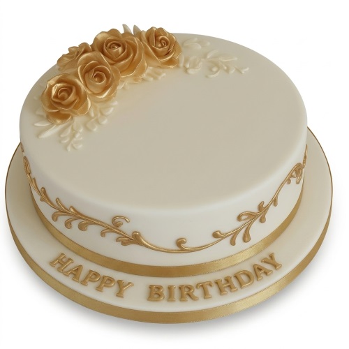 Round cream birthday cake with gold sugar roses and gold scrollwork, with 'Happy Birthday' on the board.