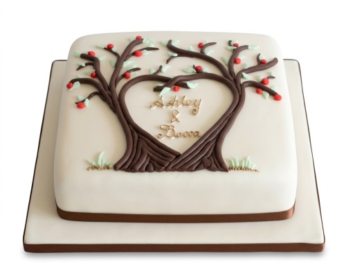 White square cake with two brown trees forming a heart, decorated with red berries and green leaves, with custom names.