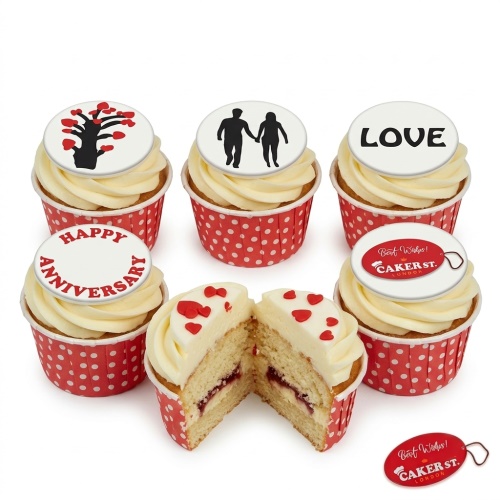 Anniversary cupcakes with white frosting, red polka dot cases, and romantic love-themed toppers.